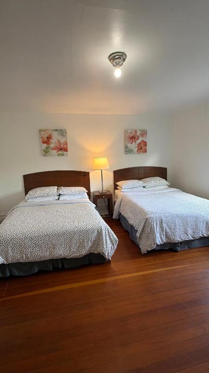 a bedroom with two beds and a lamp at Van Guesthouse in Vancouver