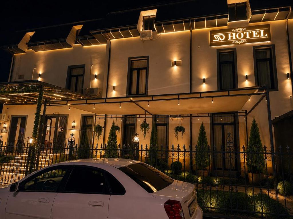 a white car parked in front of a hotel at Luna Plaza Hotel in Lunacharskiy Bekati