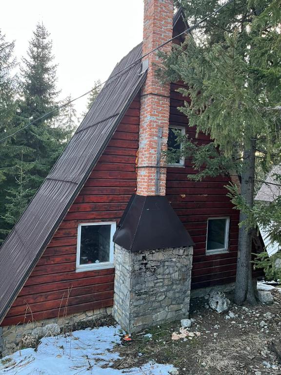 a red house with a chimney on the side of it at Vikendica Lovinovic Vlasic in Šišava
