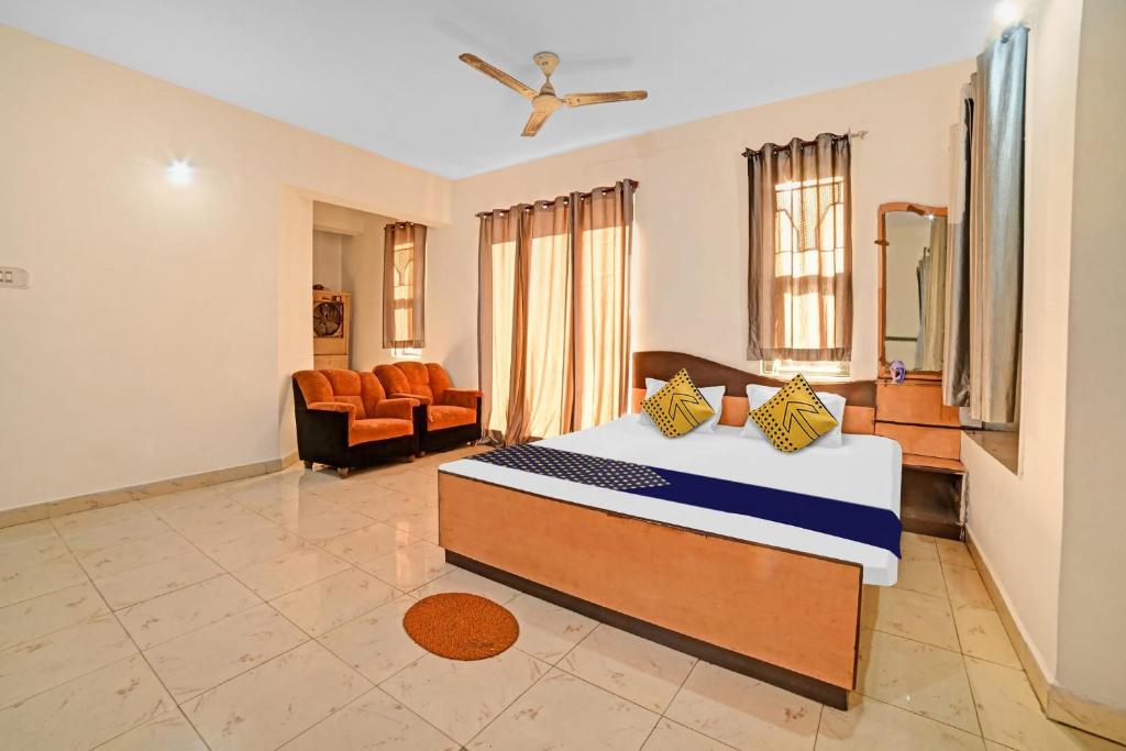 a bedroom with a bed and a living room at Hotel O SS in Chandrapur