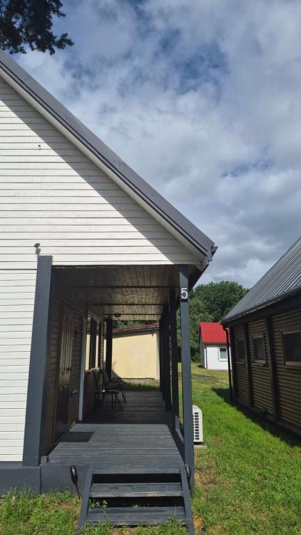 a building with a porch with a wooden deck at Amber coast - domek nr 5 in Jantar