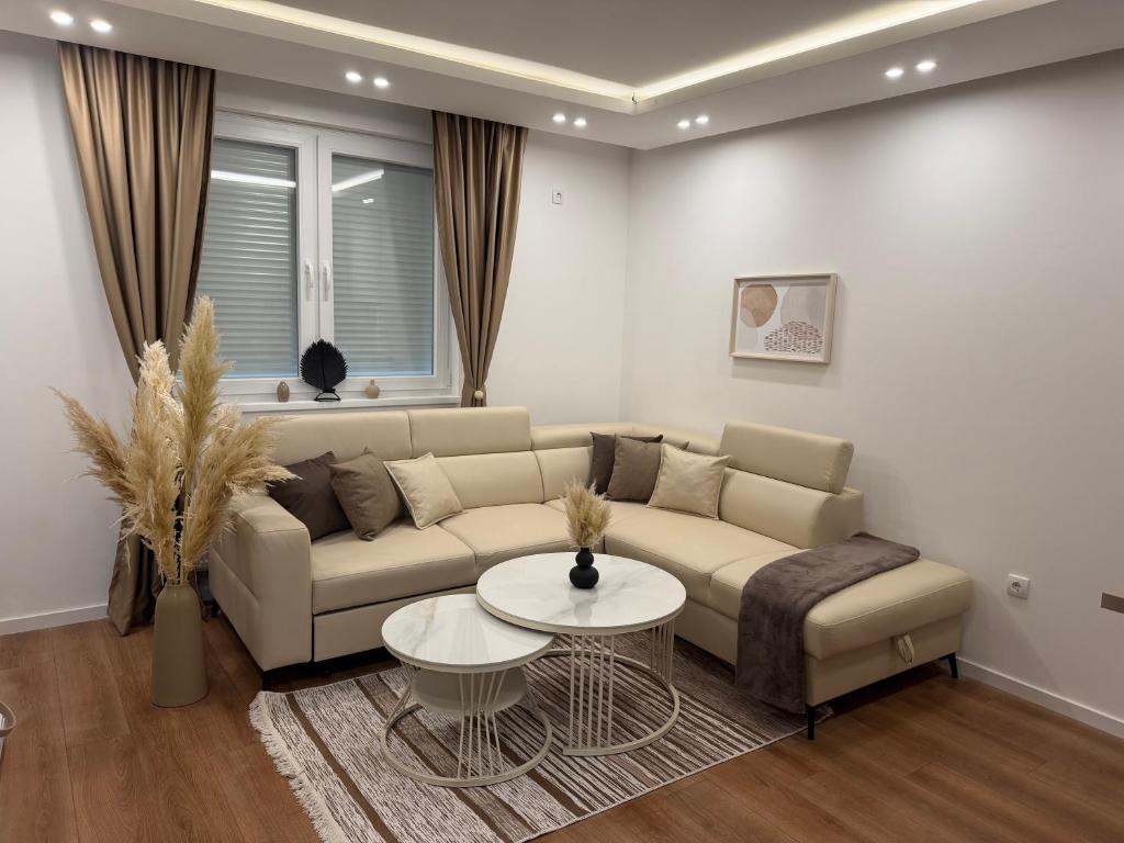 a living room with a couch and a table at Apartman Daniela Lake View in Donje Mladice