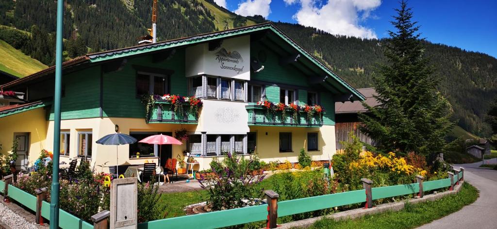 a green and white building with flowers in front of it at Appartment Sonnenkogel in Holzgau