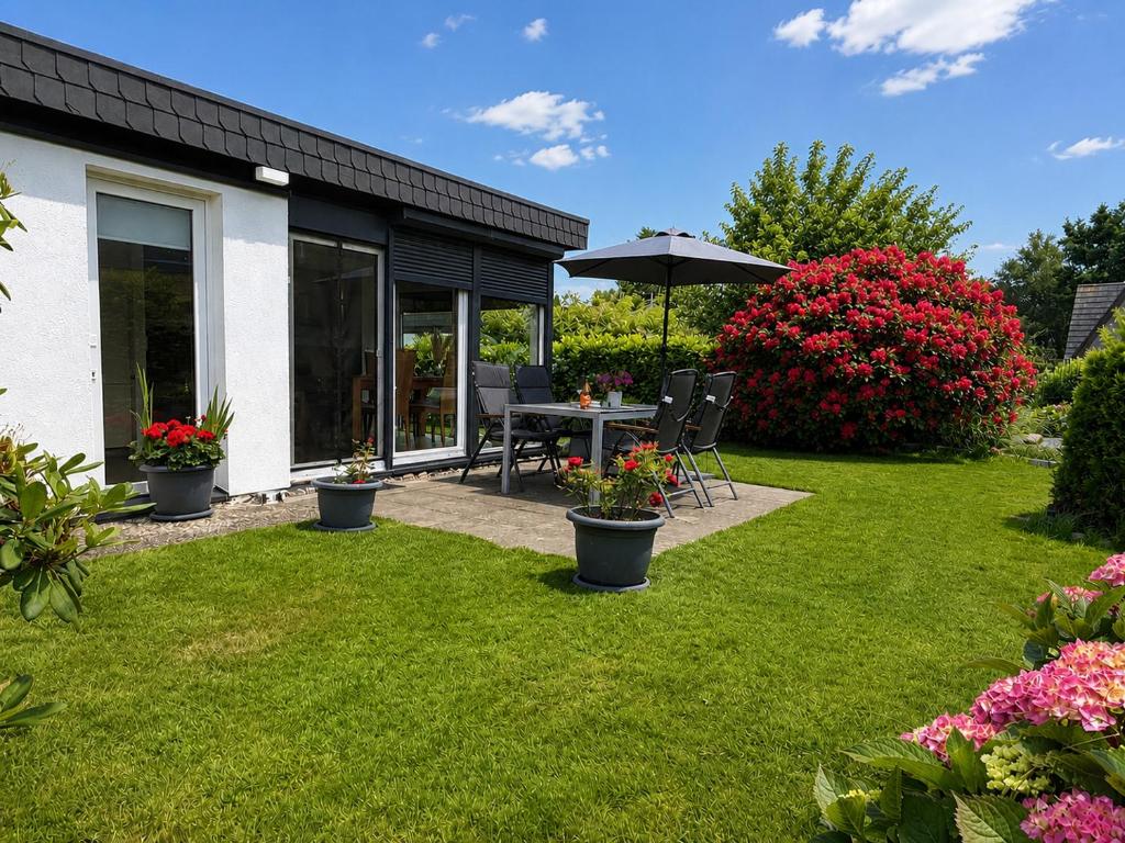 a garden with a table and an umbrella at Zwischen Schlei & Ostsee in Kappeln