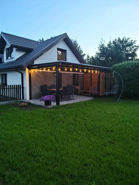 a house with a patio with lights on it at Domki u Ewy in Spychowo