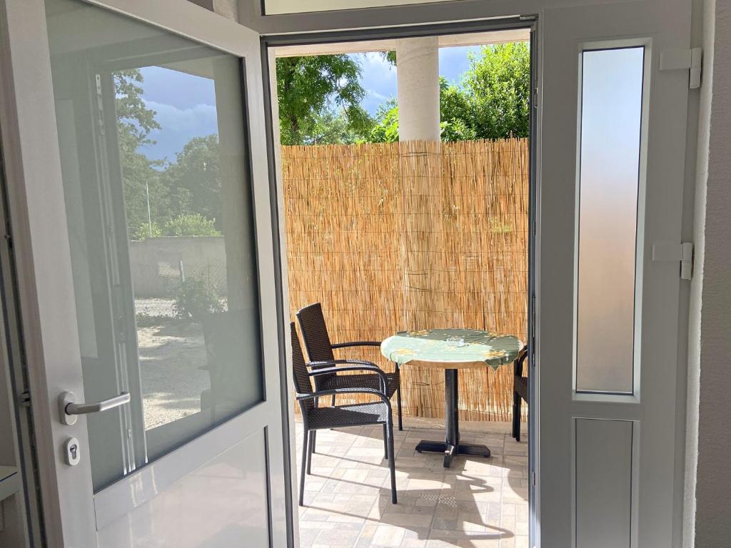 a glass door leading to a patio with a table and chair at Apartment MiA with WIFi and private garden in Pavicini