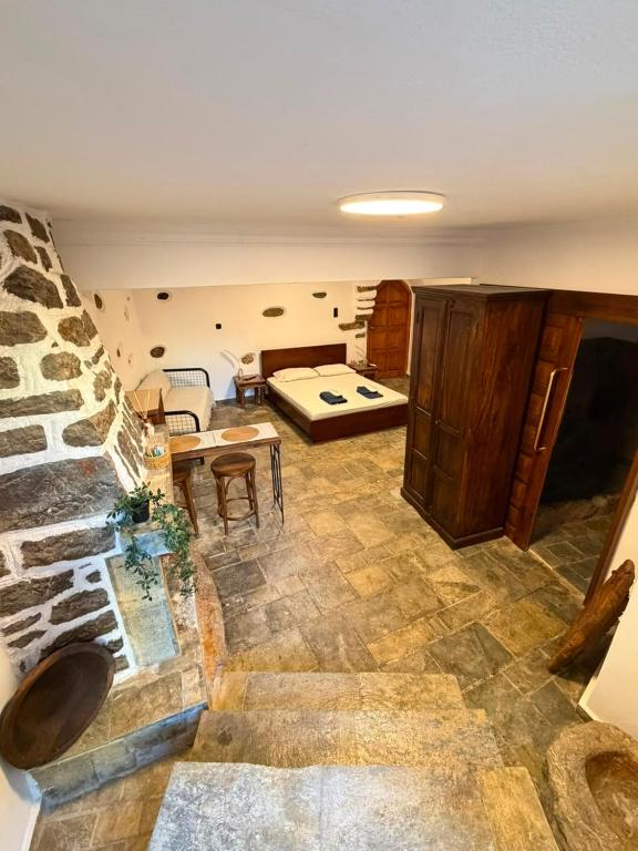 a living room with a bed and a stone wall at Dukes place in Mestá