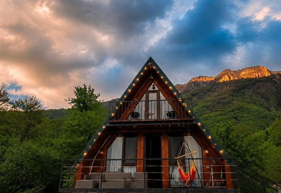a house with lights on the side of it at Mountain Shadow Cottage in Racha in Ghebi