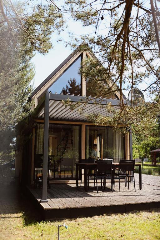 a house with a table and chairs on a deck at Sasinko Mini in Sasino
