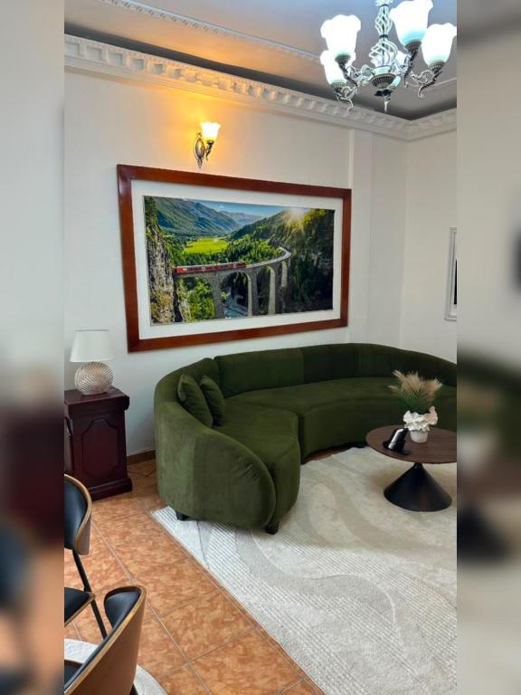 a living room with a green couch and a table at SWISS Residence Denver in Douala