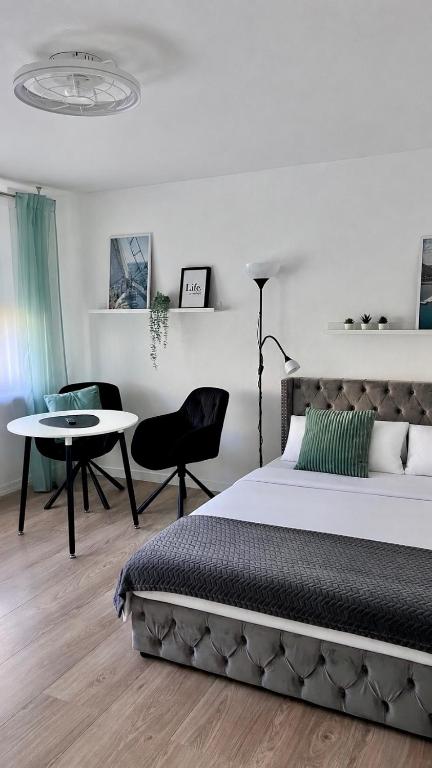 a bedroom with a bed and a table and chairs at LouVi in Kehl am Rhein