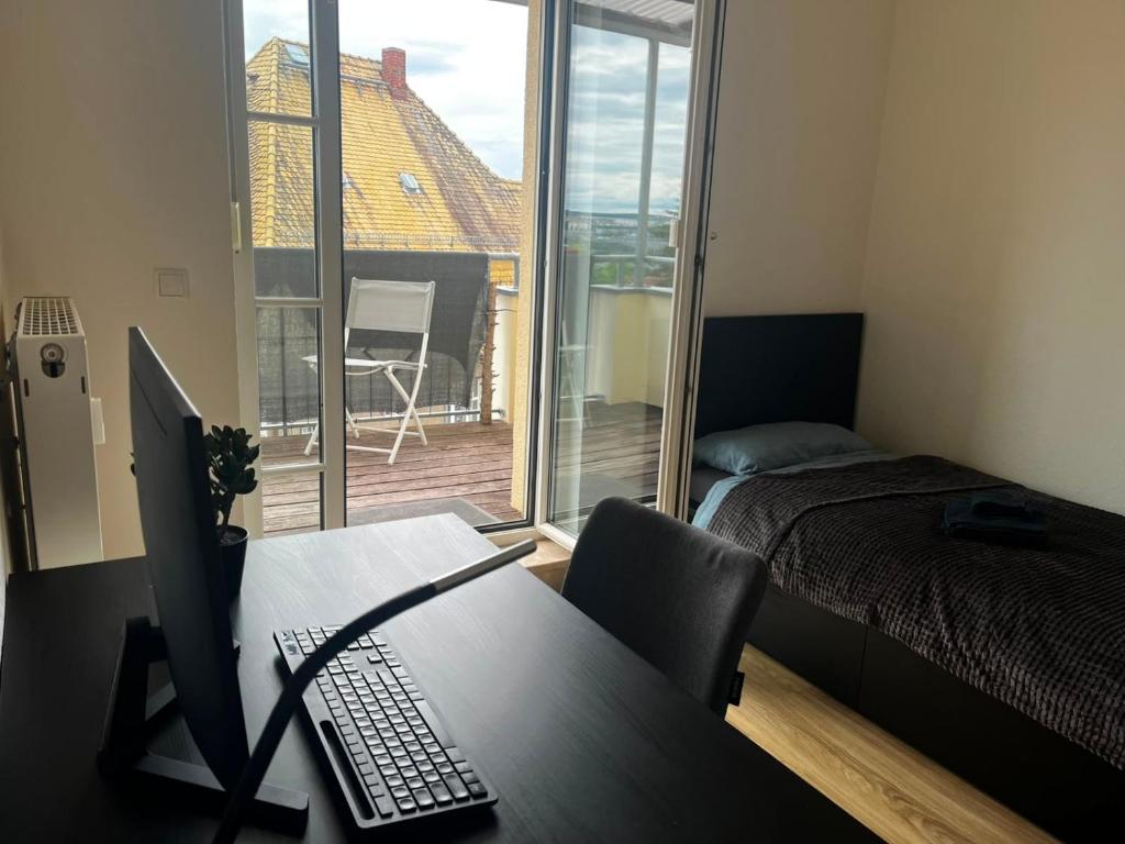 a room with a desk with a computer and a window at Ruhiger Flussblick vom Balkon all-in 5G in Gera