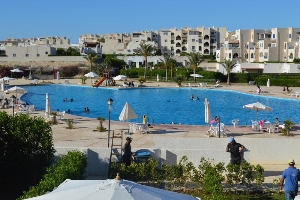 a large swimming pool with buildings in the background at Pool View Chalet in El Alamein