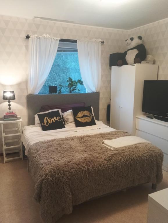 a bedroom with a bed with pillows and a window at The Creative Studio Apartment in Piteå