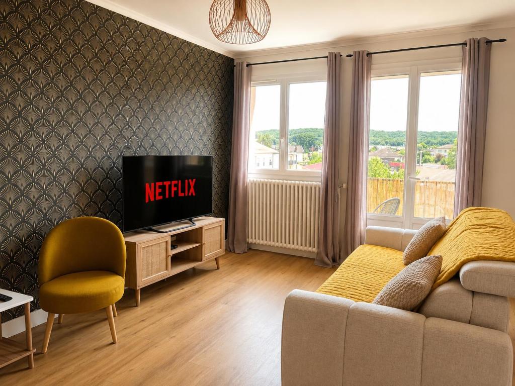 a living room with a couch and a tv at Le Panorama Chic 4prs-Parking in Bourg-en-Bresse