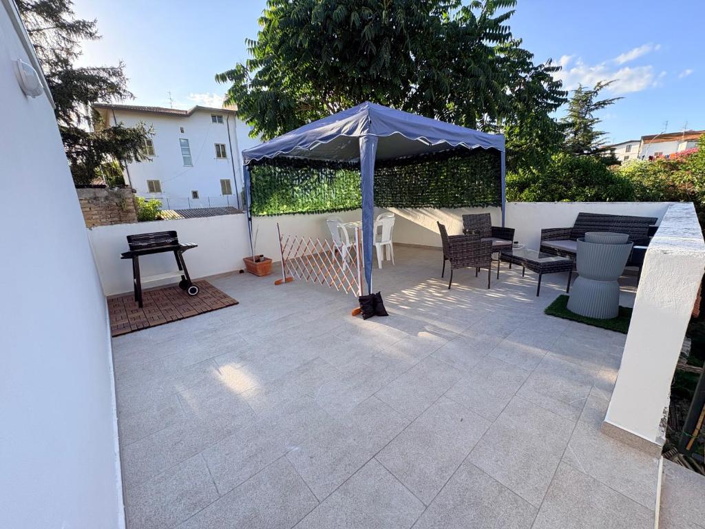 a patio with a blue umbrella and a table and chairs at La Terrazza in Ortona