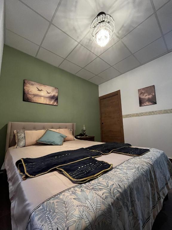a bedroom with a large bed with a chandelier at El Palmar in Tobarra