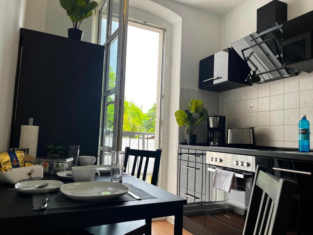 a kitchen with a table with plates on it at Stylische Flat1 mit französischem Balkon1 all-in 5G in Gera