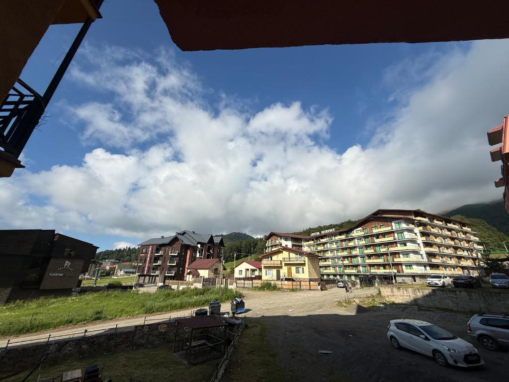 a view of a parking lot with buildings and cars at Didveli Mountain Apartment in Bakuriani