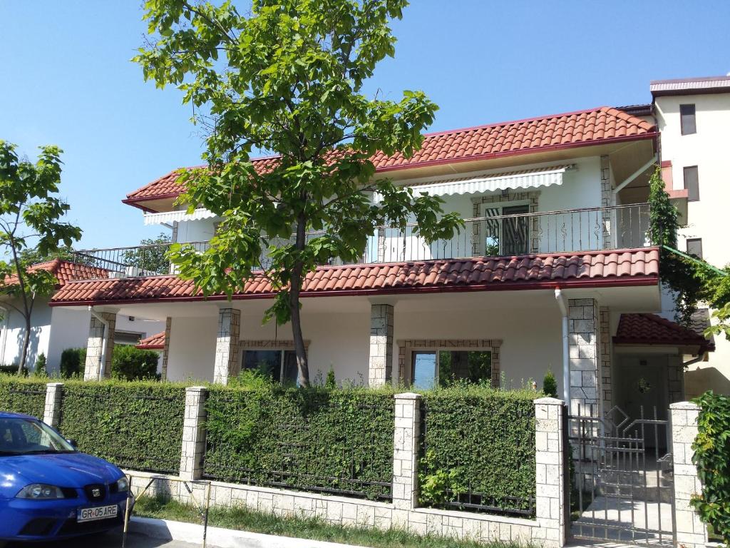 a house with a fence and a car parked in front at Apartamente Mitu in Eforie Nord