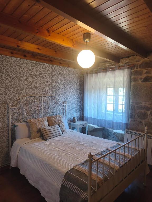 a bedroom with a large bed and a window at Casa Pancha in Cerdeda