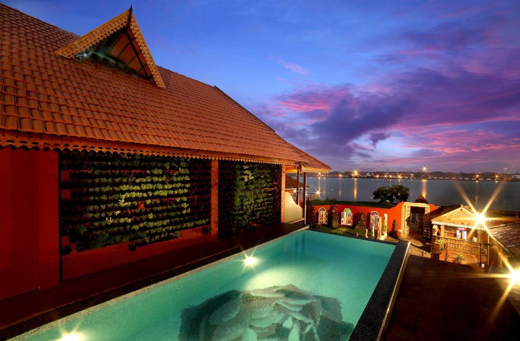 uma piscina ao lado de um edifício com um edifício em Ginger House Museum Hotel em Cochin