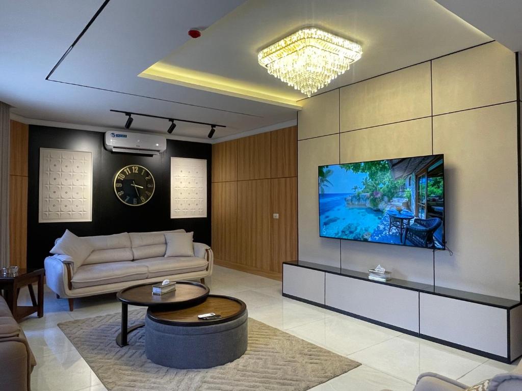 a living room with a couch and a tv on a wall at ريڨا للأجنحة السكنية Riva suites in Irbid