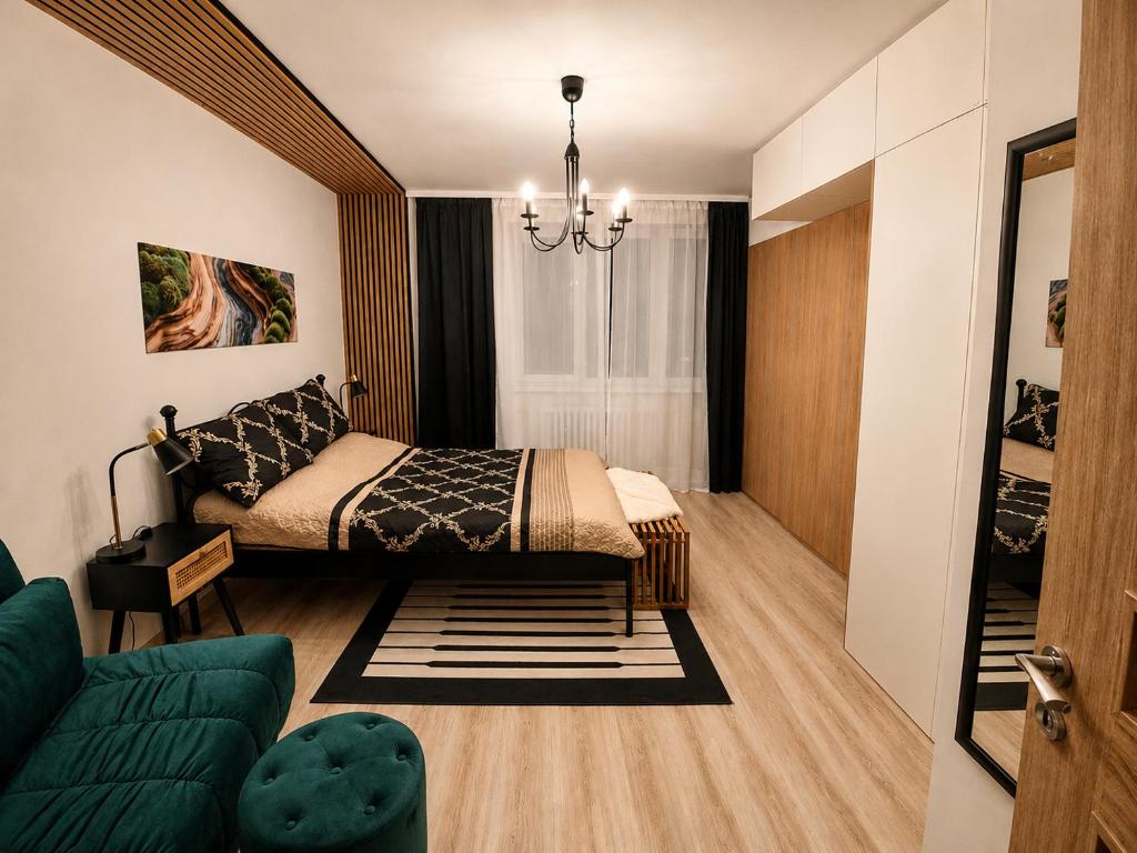 a bedroom with a bed and a couch at Bytča Central Apartment in Bytca