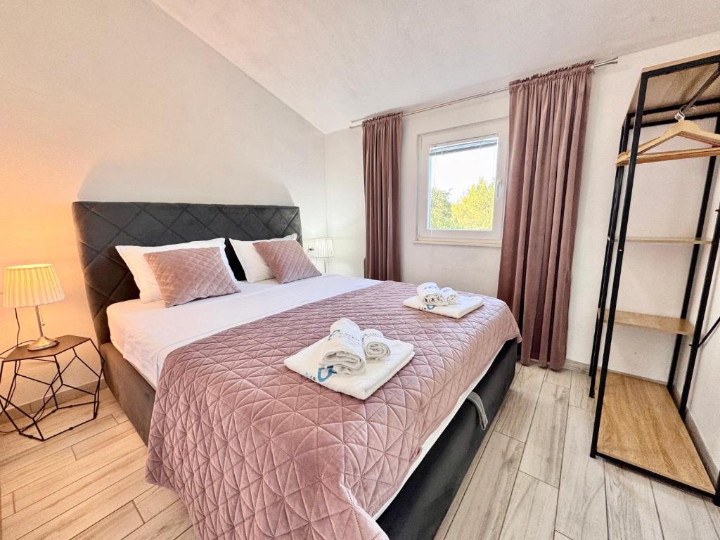 a bedroom with a bed with towels on it at Apartments Fortuna in Biograd na Moru