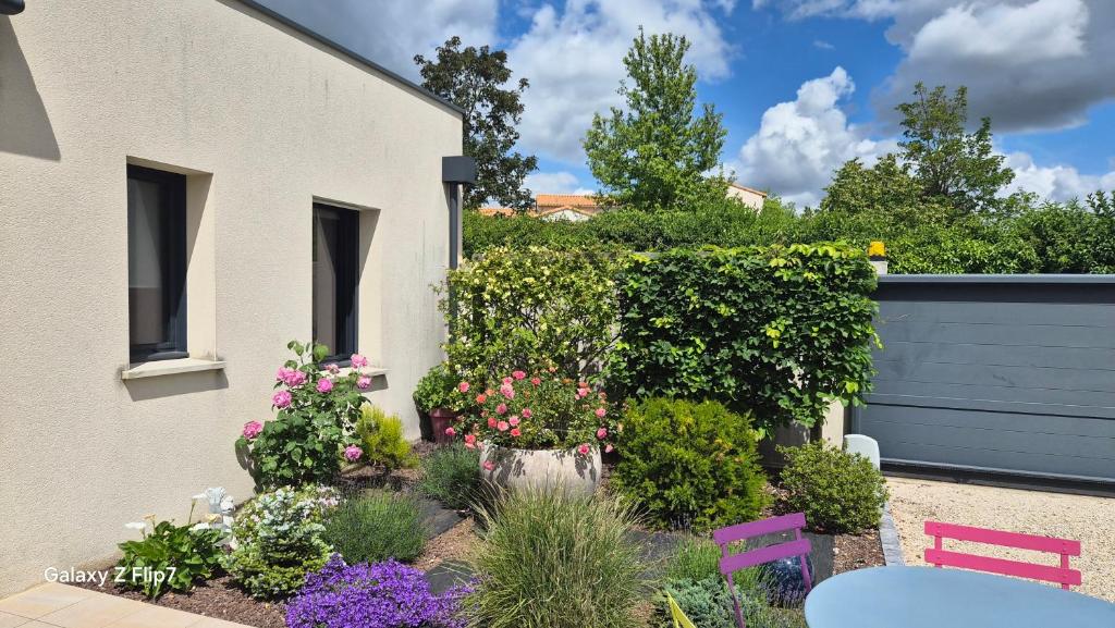 a garden with flowers and plants next to a building at AU GRAIN D'ORGE in Échiré