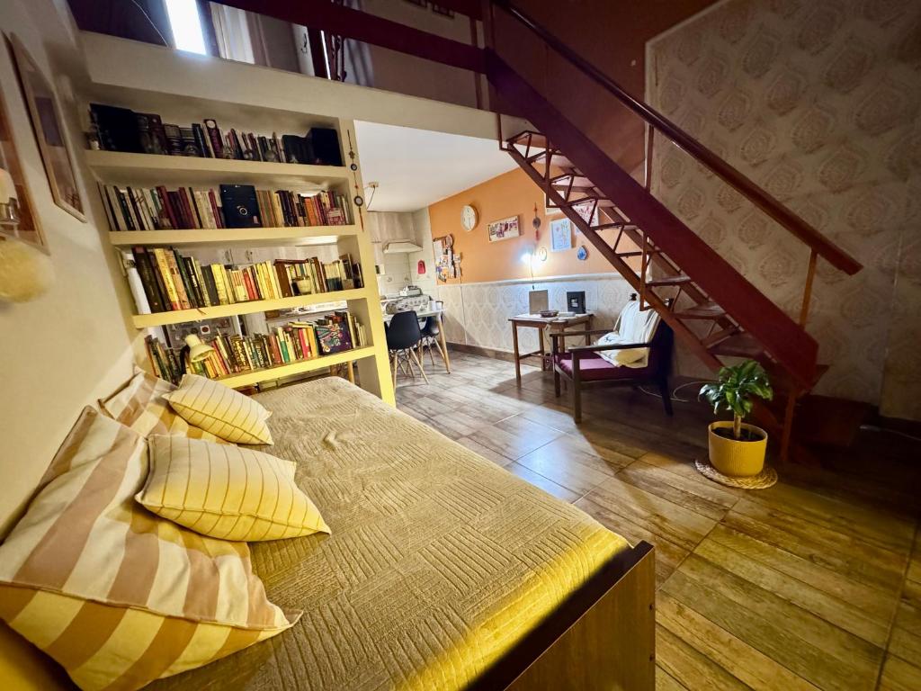 a bedroom with a bed with yellow pillows and a staircase at Loft Helena - acogedor, completo y céntrico in Jesús María