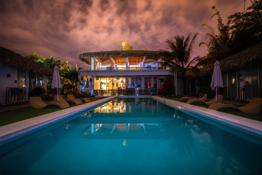 a swimming pool in front of a house at night at Vikara in Olón