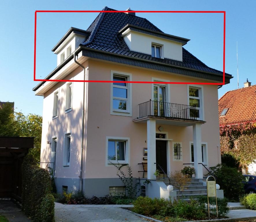 a white house with a black roof and a red rectangle at Tal-Residenz in Bad Salzuflen