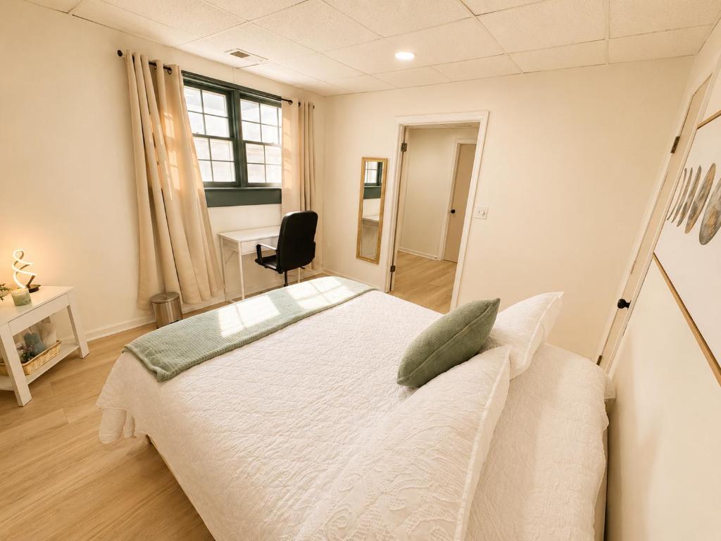 a bedroom with a large white bed and a desk at Elegant Boutique Stay in Lilburn
