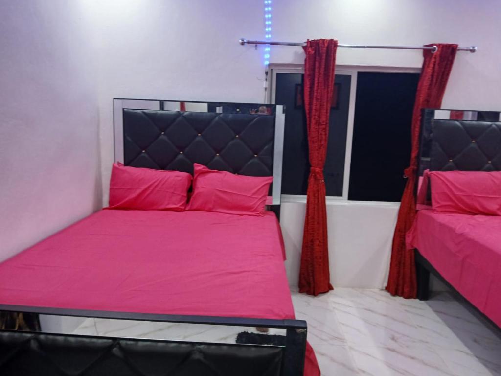 a bedroom with a bed with pink sheets and a window at Skyview Palace in Morant Bay