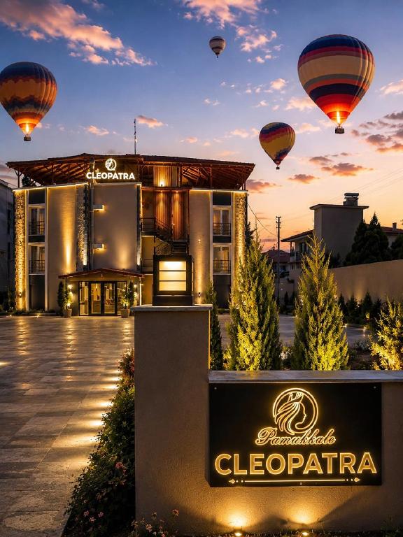 a sign in front of a hotel with hot air balloons at Pamukkale Cleopatra in Pamukkale