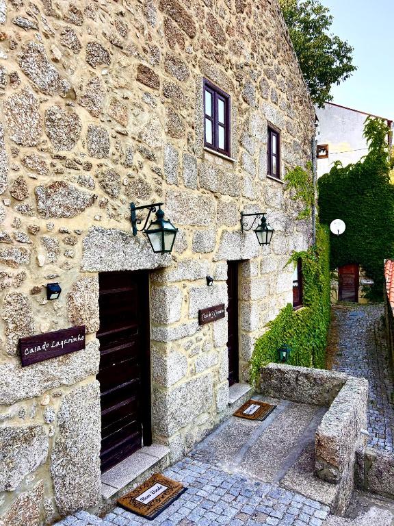 a stone building with a door and a sign on it at Casas Serranas in Gouveia