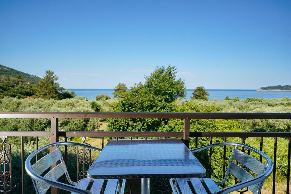 a table and chairs on a balcony with the ocean at Athina Villa in Koinyra
