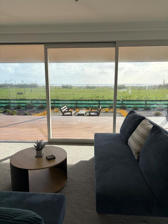 a living room with a couch and a large window at Carters Beach Escape in Carters Beach