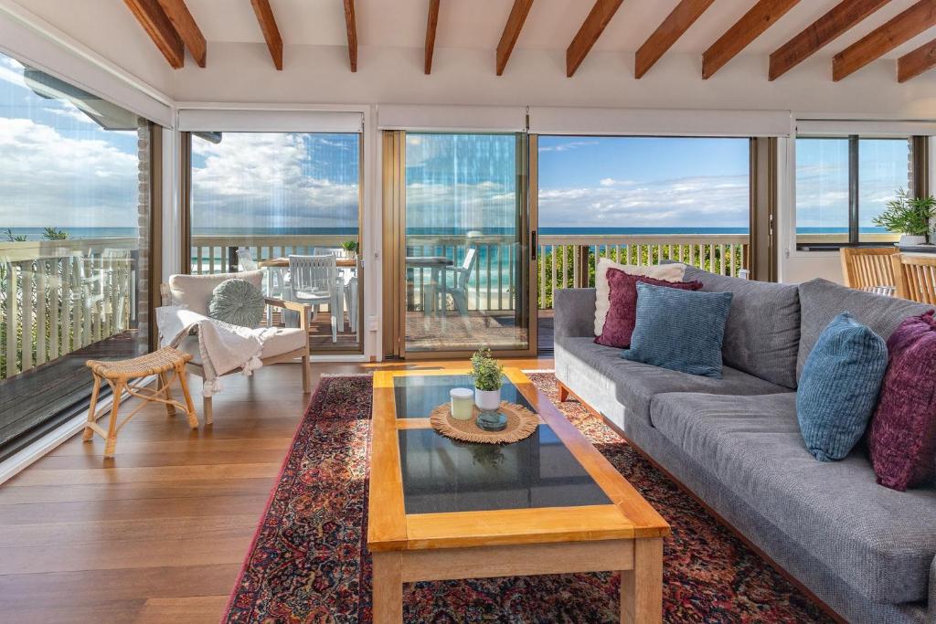 a living room with a couch and a table at Lawsons at Blueys in Blueys Beach