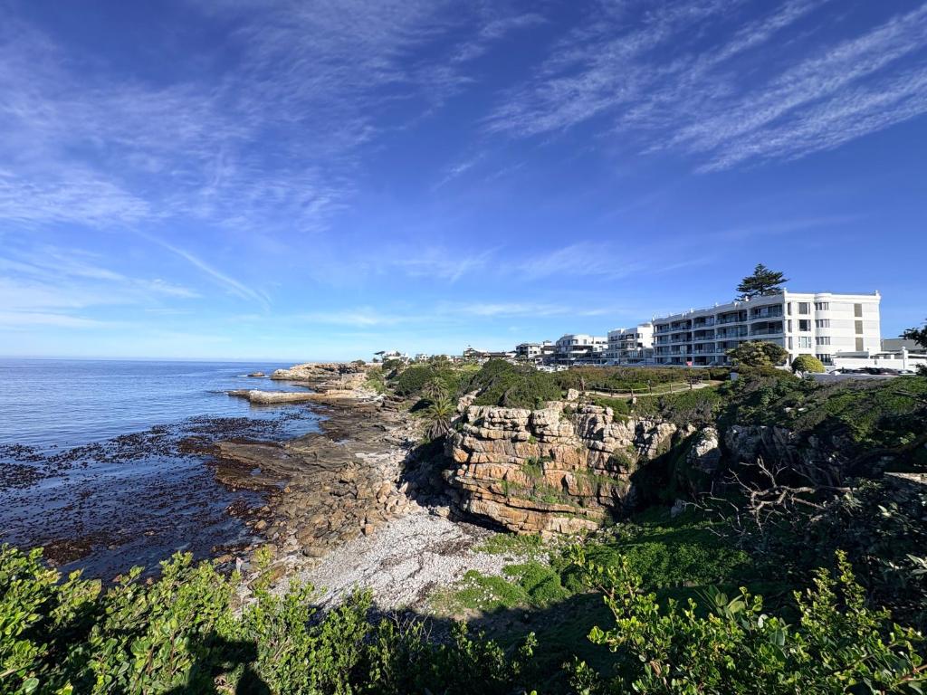 a building on a cliff next to the ocean at Little Acorn in Hermanus