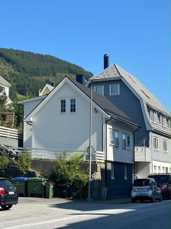 a large white house with cars parked in a parking lot at Apartment in Måløy in Måløy