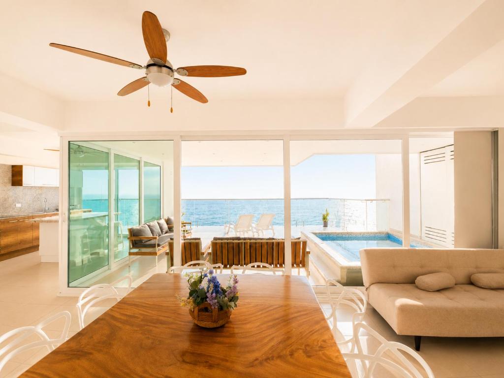 a living room with a ceiling fan and a pool at Resort Playa Azul Departamentos Frente al Mar in Tonsupa