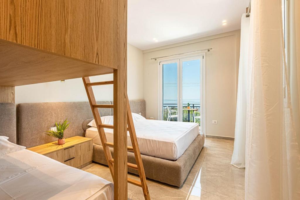 a bedroom with two bunk beds and a balcony at New Dhermi Icon 3 - Parking in Dhërmi