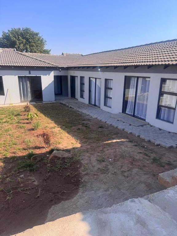 a white building with a yard in front of it at The Gardens view lodge in Bushbuckridge