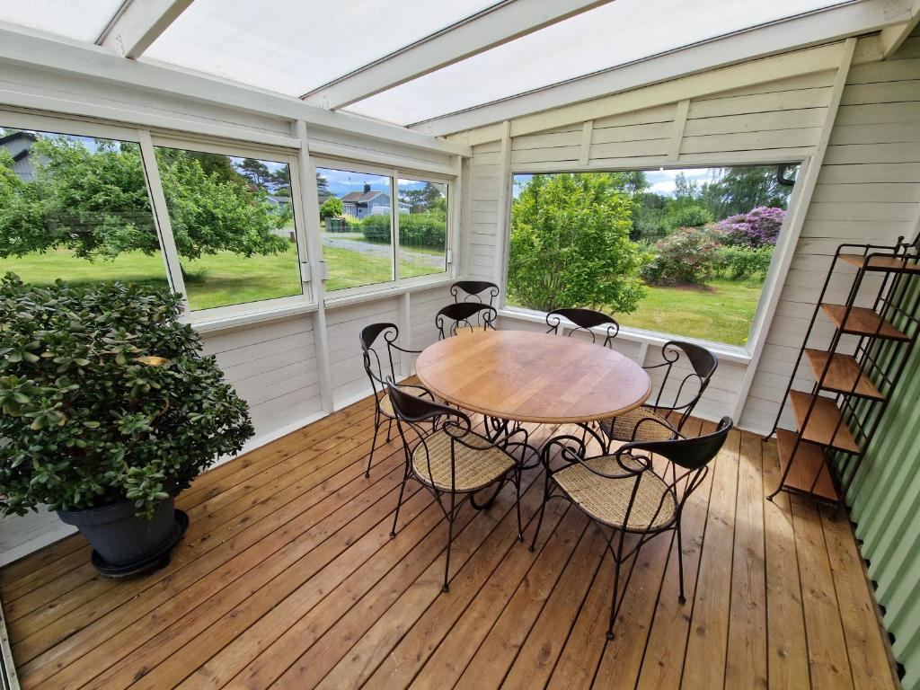 a screened porch with a table and chairs on it at Havsnära stuga in Varberg