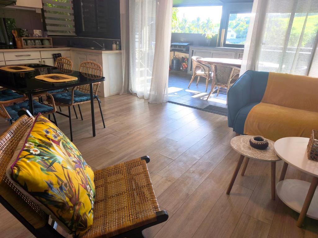 a living room with a couch and a table at Ti Kaz Luxuriante - Jacuzzi Privé - Évasion Tropicale & Intimité in Saint-Louis