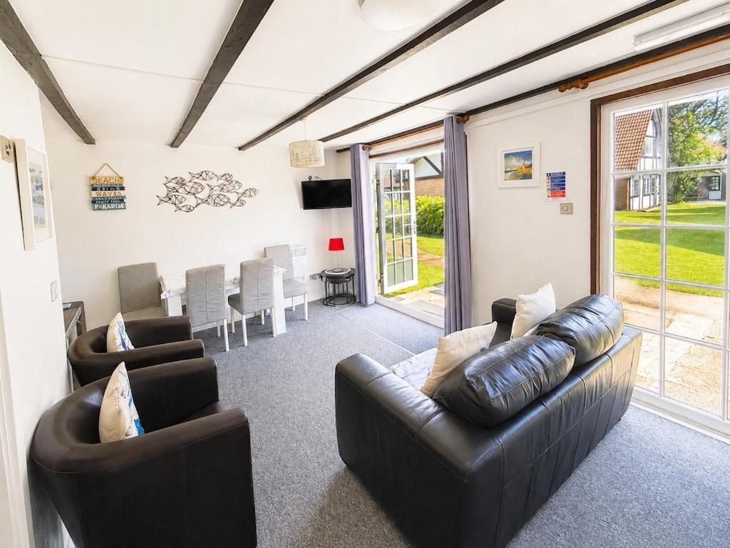 a living room with two leather couches and a table at Cornwall Cosy Bungalow in Hayle