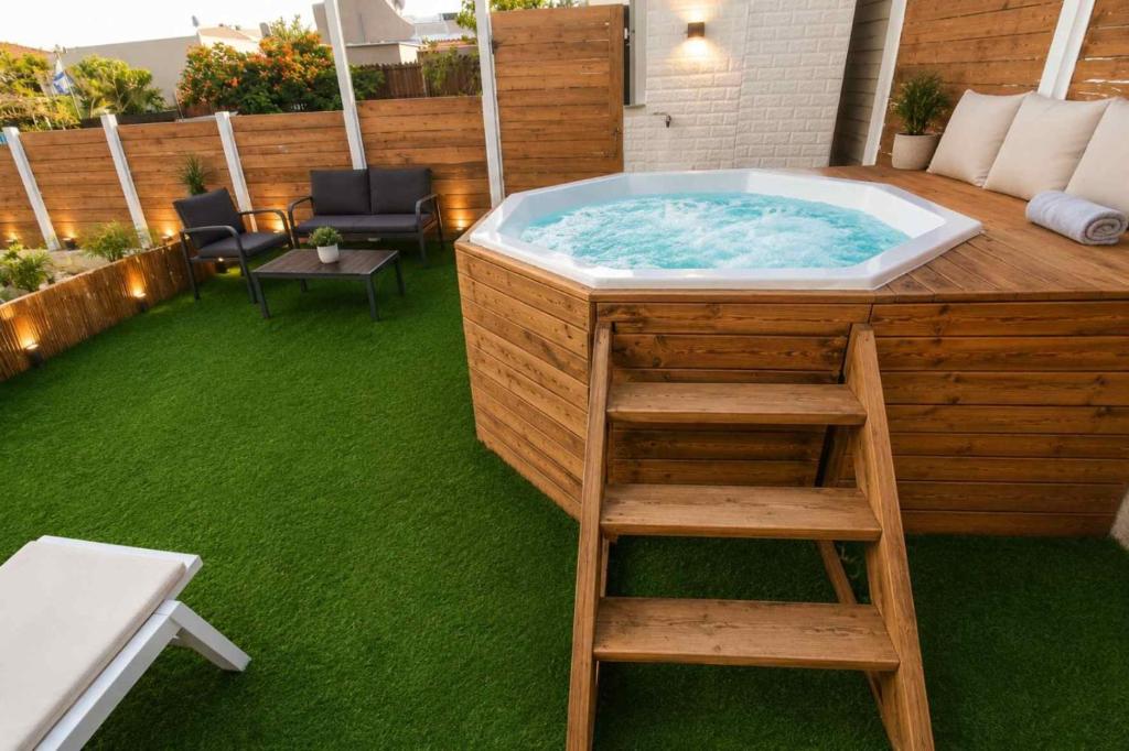 a jacuzzi tub in a deck with a ladder at Barak Royal Suites 20 sea view - ג'קוזי בחצר ומרפסות עם נוף לים in Eilat