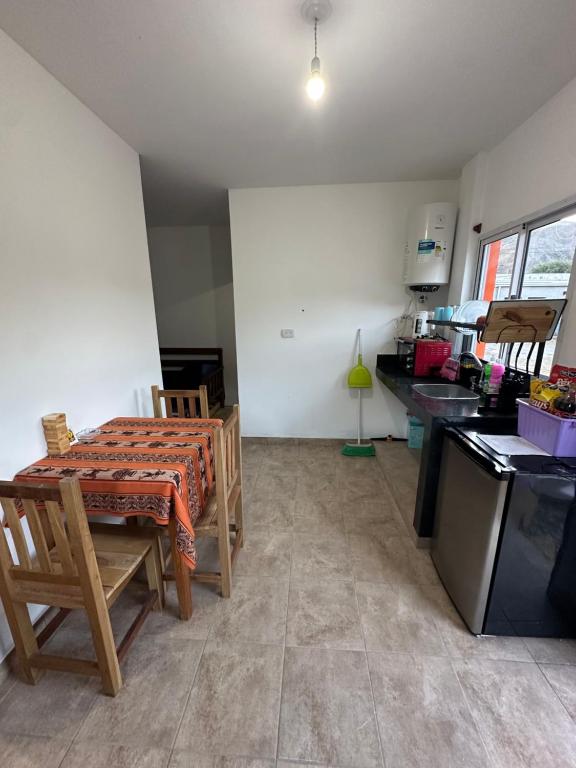 a kitchen with a table and chairs in a room at Hospedaje ESMERALDA in Volcán